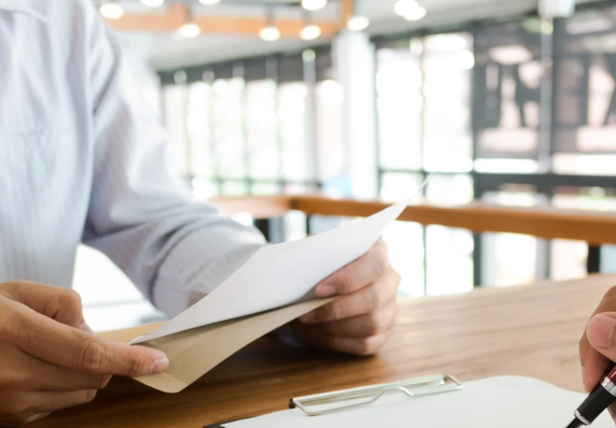 Professional reading an open printed quick start guide booklet with architectural diagrams.